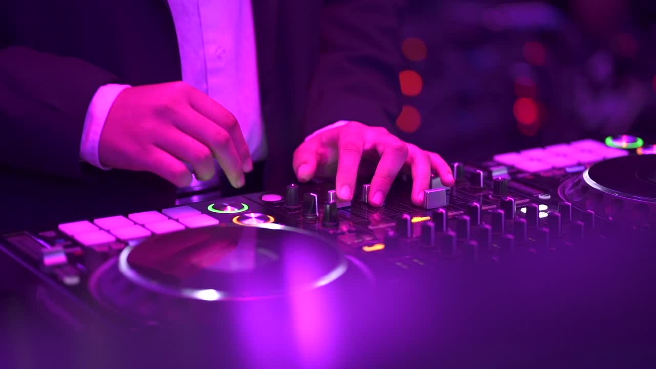 las manos del dj ajustando los controles móviles en una cubierta de mezclador dentro del club