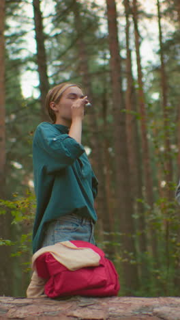 amigos disfrutan de un momento de paz en el bosque, uno vertiendo bebida caliente del termo para otro, que sonríe en agradecimiento, rodeados de árboles altos, comparten un vínculo en la naturaleza
