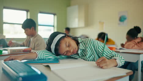 girl sleeping at desk in classroom