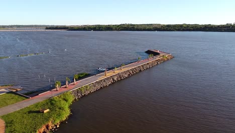 a scenic panoramic outlook of the river is encompassed by tree-covered banks and highlighted by a stunning natural dock that extends deep into the water