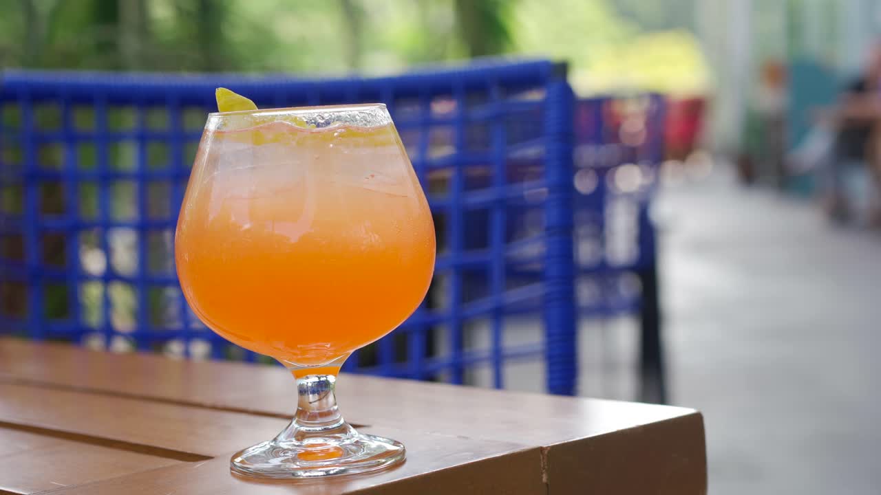 Donna prende un cocktail e si rinfresca in giardino