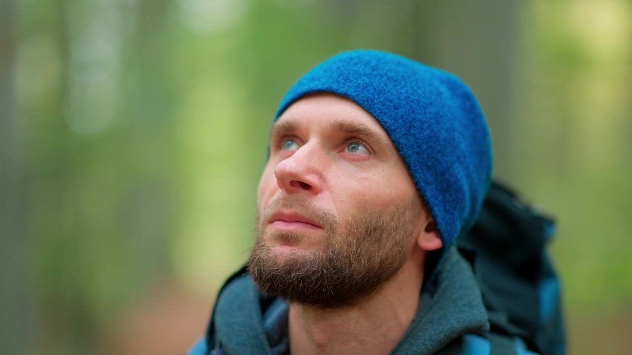 Thoughtful Hiker Man Looking Up in Green Forest