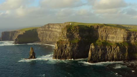 slow motion shot of waves crashing at cliffs of moher, static aerial