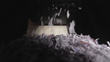 Shredder-Cutting-Paper-From-Below,-Half-Full-Basket,-Wide-Angle