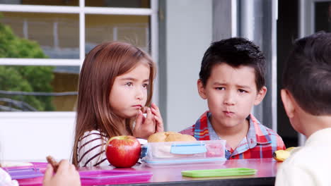 four elementary schoolchildren having lunch together