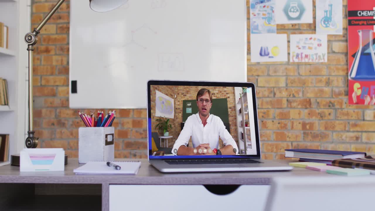 Professor caucasiano exibido na tela do notebook durante videochamada