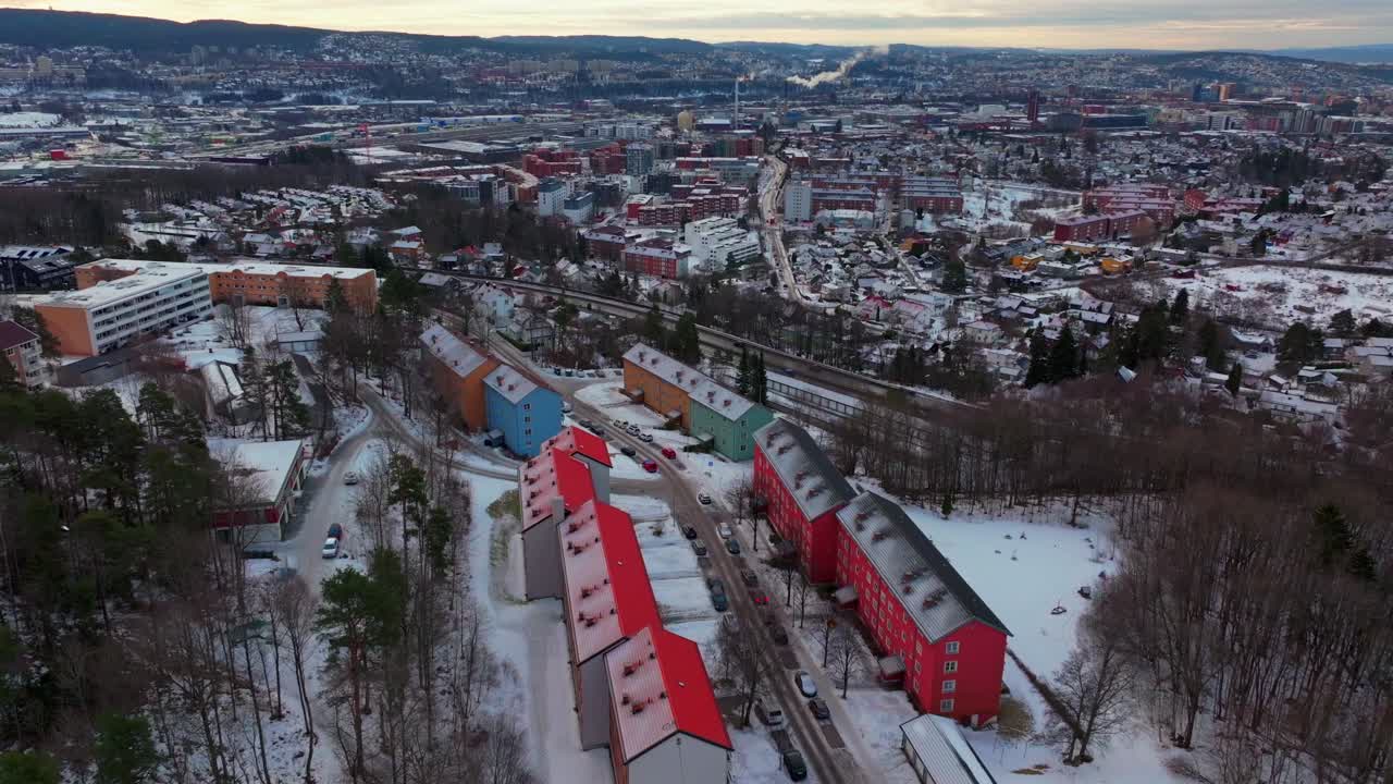 Tonsengagen Bjerke Arvoll Oslo Norge Norway aerial drone morning snowing snow flakes cold cloudy winter day gray skies city neighborhood apartment condominiums buildings cars traffic forward pan up