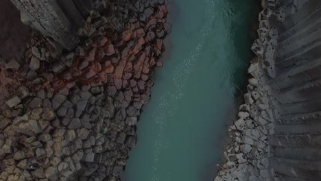 A-Bru-river-in-Studlagil-Canyon,-Iceland-with-basalt-rock-columns,-aerial-downwards-view