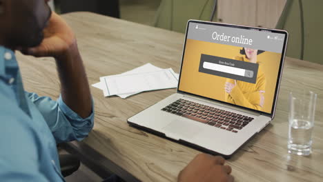 hombre afroamericano usando una computadora portátil, compras en línea de moda, cámara lenta