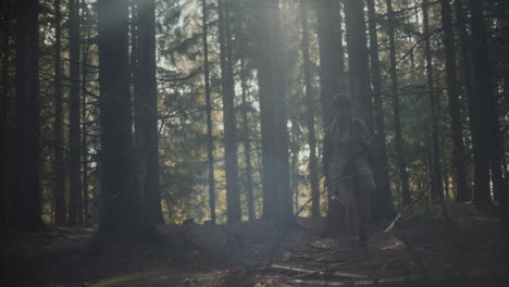 young woman walking amidst trees in forest