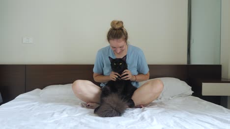 Schwarze-Maine-Coon-Katze-Verbringt-Zeit-Mit-Frauchen-Im-Bett,-Zeitlupe