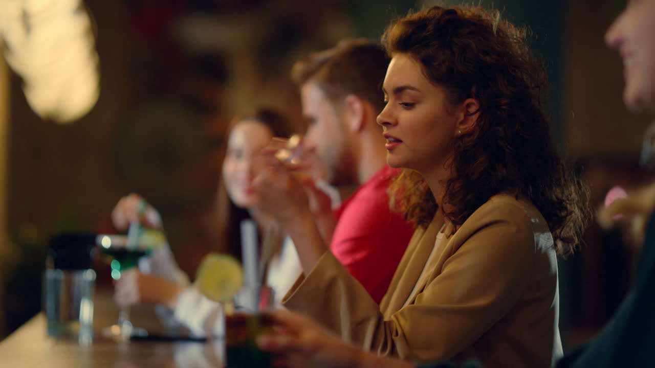 Model paying pay pass on mobile phone in bar. Woman talking girlfriend inside