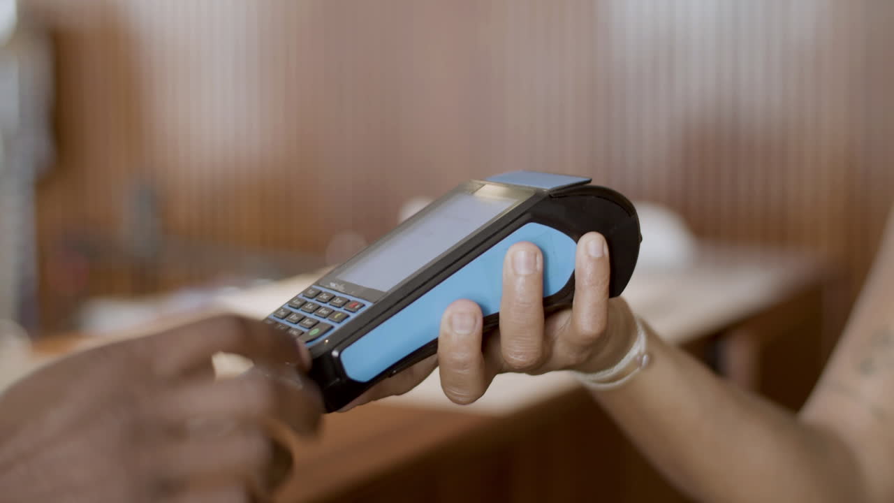 Closeup of mans hand inserting credit card in terminal.
