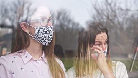dos adolescentes disfrutan de la vista afuera, en cuarentena.