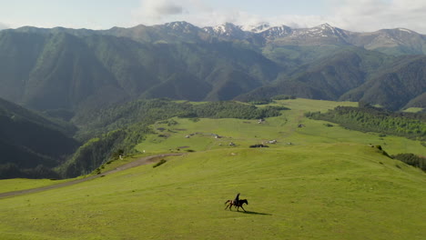 Weite,-Filmische-Drohnenaufnahme-Eines-Mannes,-Der-Auf-Einem-Pferd-In-Upper-Omalo,-Tusheti-Georgia,-Reitet