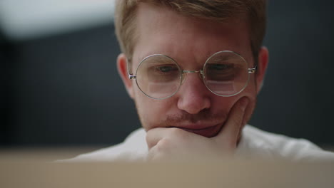 Un-Hombre-Inteligente-Con-Gafas-Está-Mirando-La-Pantalla-Del-Portátil-Y-Leyendo-Noticias-O-Retratos-De-Primer-Plano-De-Datos