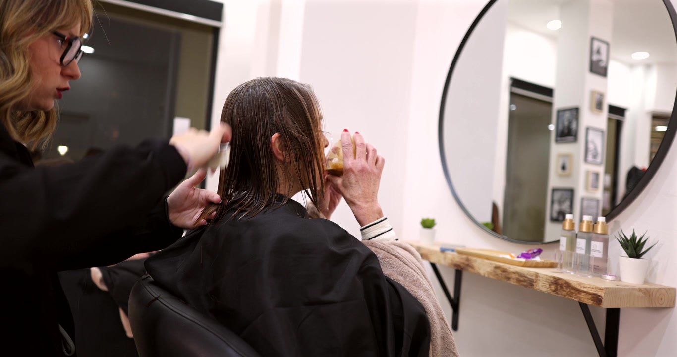 Professional Hairdresser Cutting Client's Hair in Modern Salon