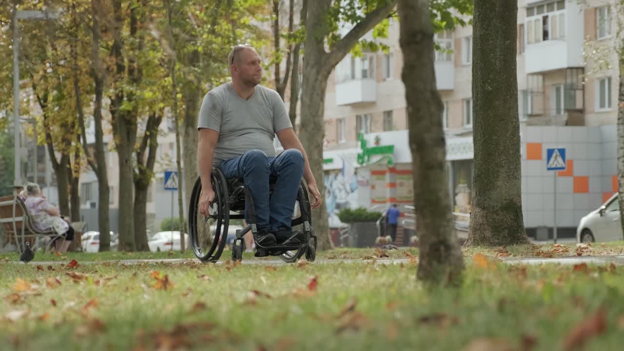 hombre con discapacidad en silla de ruedas camina por el callejón del parque