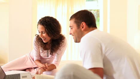 Woman-showing-her-boyfriend-something-amusing-on-her-laptop