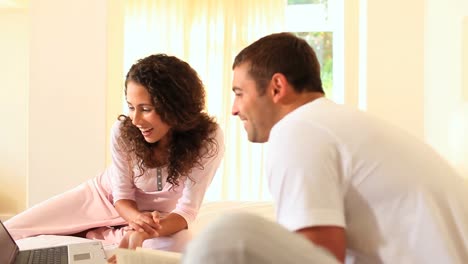 woman showing her boyfriend something amusing on her laptop