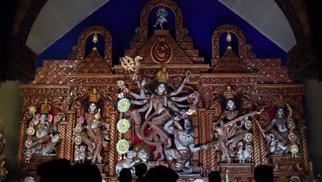 beautiful idols and sculptures of hindu gods and goddesses being worshipped in temples and pandals in festivals by devotees in silhouette