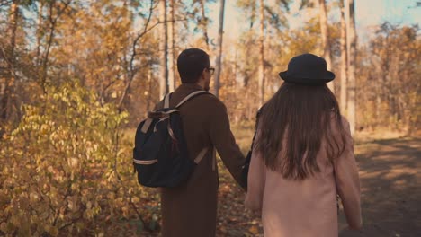 una pareja caminando por el bosque de otoño.