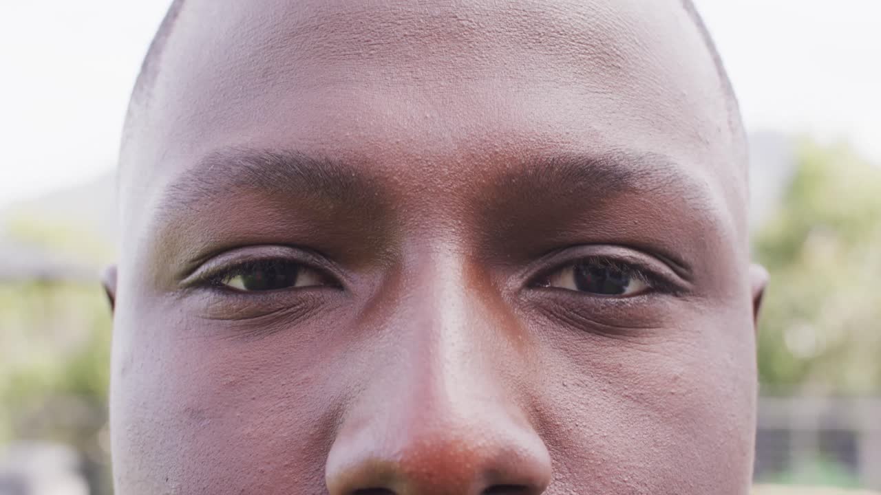 Nahaufnahme eines Videoporträts der Augen eines lächelnden afroamerikanischen Mannes im Freien