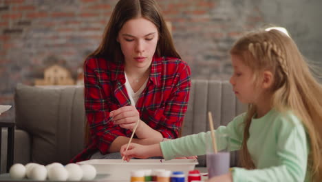 la hermana mayor atenta ayuda a la niña a dibujar mármol