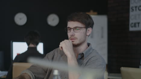 Stressful-business-man-stretching-hands-front-computer-in-night-office