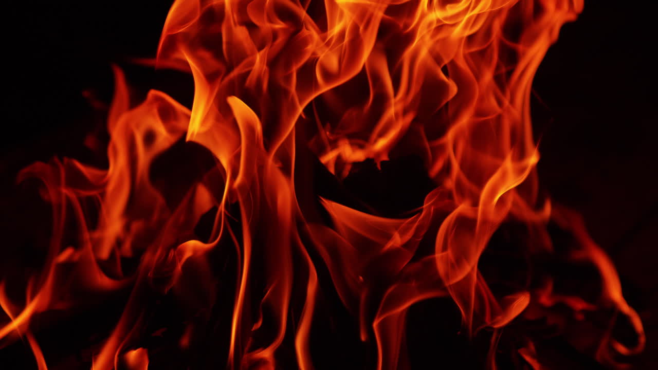 Red hot flame on the chops of wood. Close up look at the campfire burning at night.