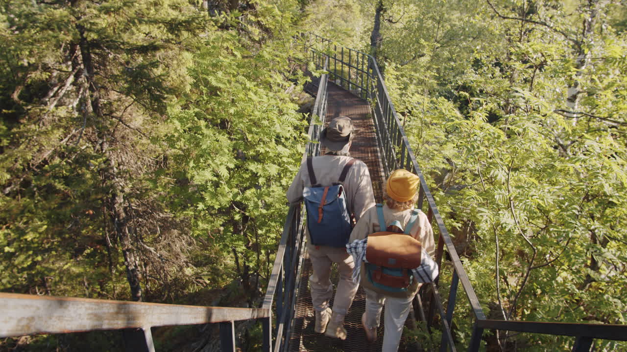 pareja de senderismo en un puente del bosque