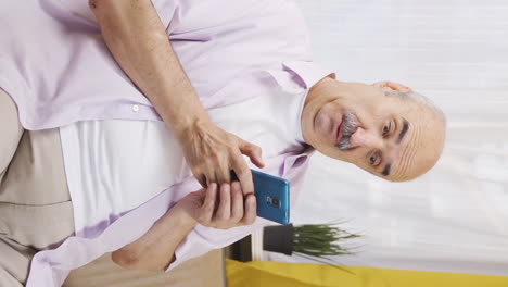 Vertical-video-of-Happy-and-happy-texting-old-man.