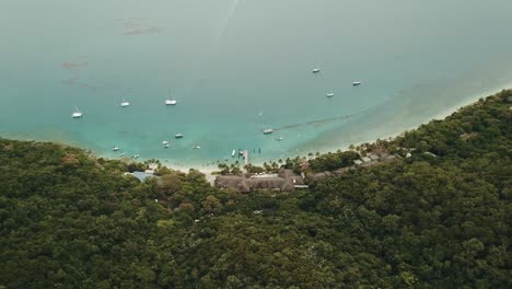 Drohnenschwenk-über-Fitzroy-Island-Resort-Und-Boote-Auf-Dem-Tropisch-Blauen,-Klaren-Wasser