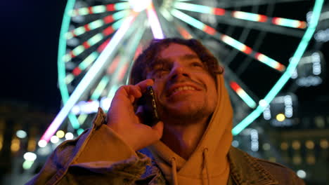 Cheerful-man-speaking-by-cellphone-outdoor.-Guy-using-smartphone-on-street.