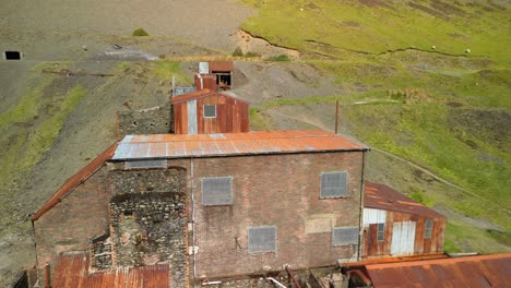 Reveal-of-abandoned-mine-buiding-with-rusty-roof-at-Force-Crag-Mine-Coledale-Beck-in-the-English-Lake-District