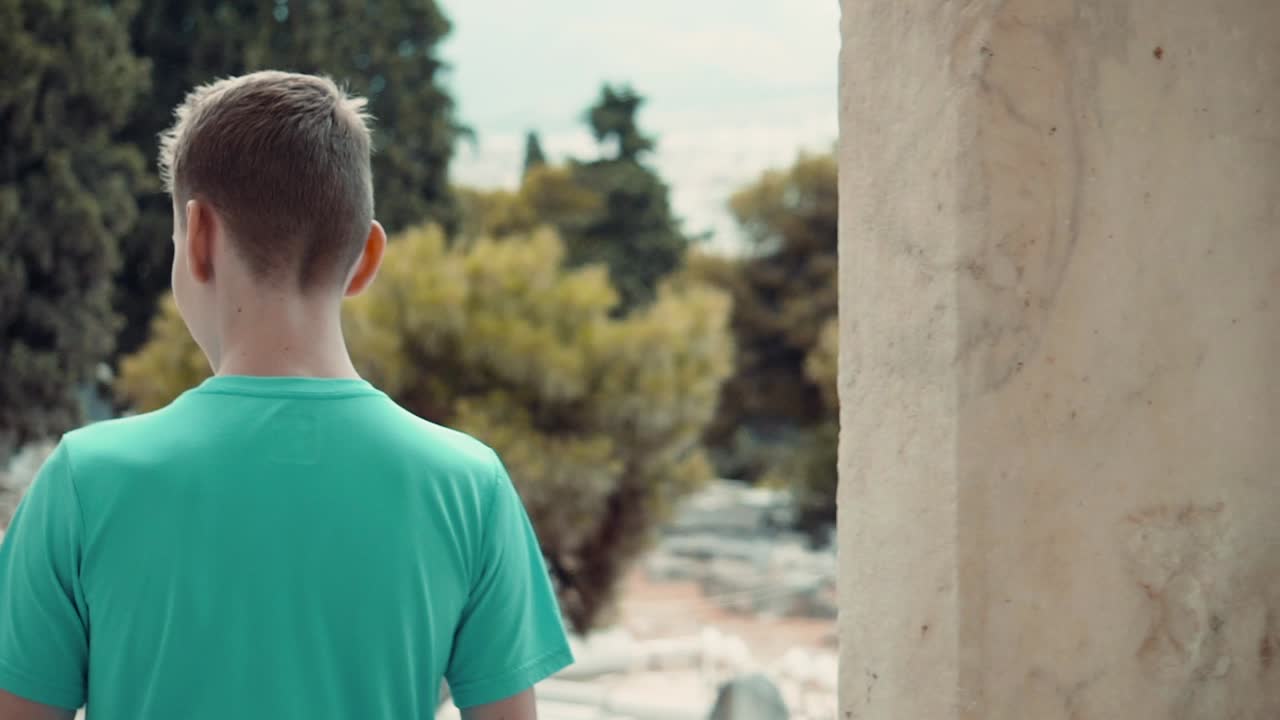 그리스 아테네의 고대 사원 유적지로 걸어 들어가는 한 남자의 클립