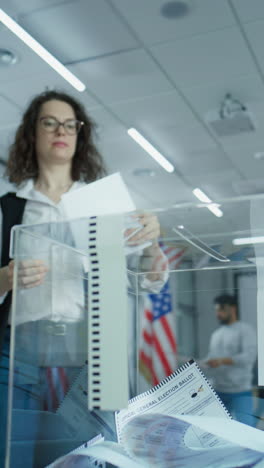 diverse voters, american people vote for future president in voting booths at polling station. caucasian woman puts ballot in box. national election day in the united states of america. slow motion.