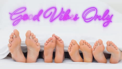 good vibes only graphic in pink neon above the feet of four people lying down