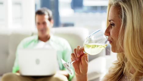 Mujer-Joven-Tomando-Una-Copa-De-Vino-En-El-Salón-De-Casa.