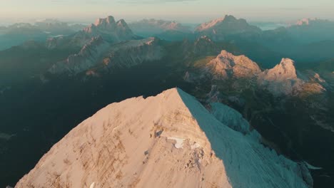 avión no tripulado en espiral alrededor de la icónica cumbre de tofana di rozes en cortina, italia como la primera luz del amanecer golpea los picos de las dolomitas