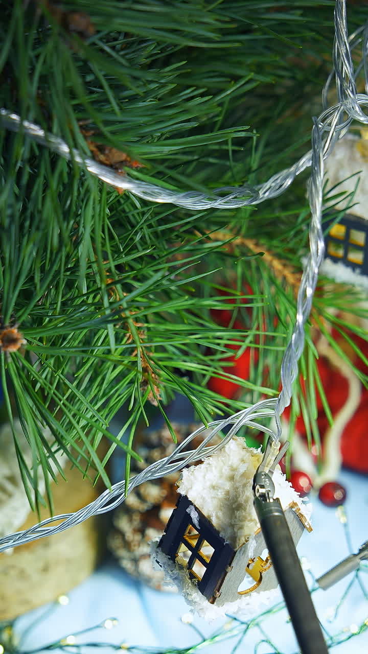 Christmas tree is decorated by robotic tools. Metal robotic arms decorating fir tree in New year. Innovations in technology. Close-up. Vertical video