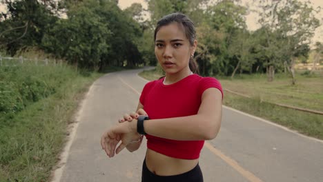 woman checking smartwatch while running outdoors