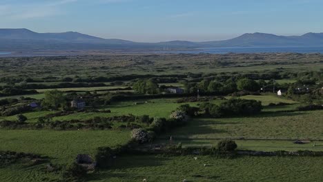 aerial view looking across idyllic welsh meadow under snowdonia mountains in the distance