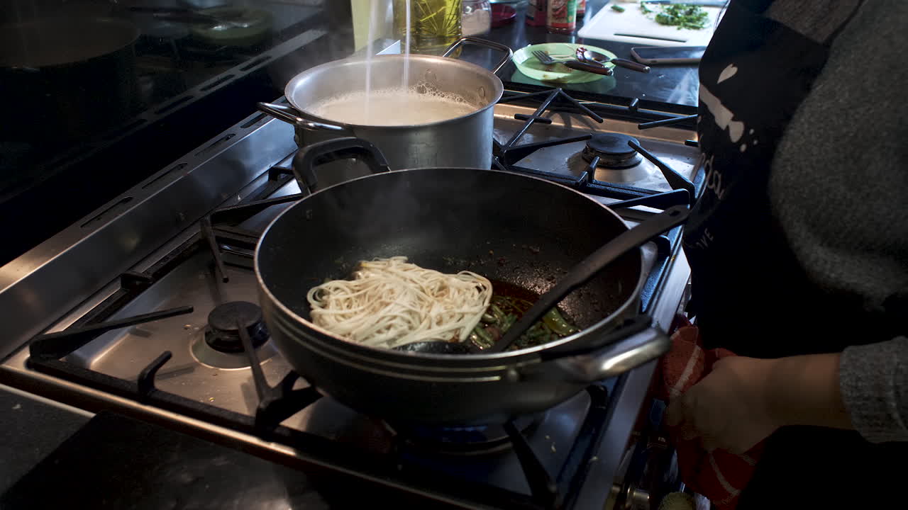 요리한 스파게티 국수를 냄비에 넣고 추가 혼합