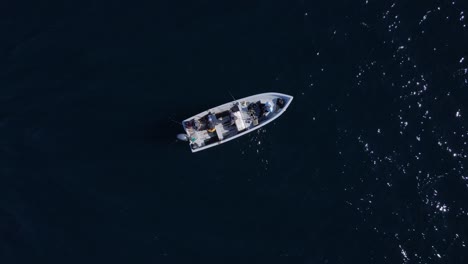 Birdseye-view-of-fisherman-on-flat-bottom-boat-prepping-rod-and-moving-equipment