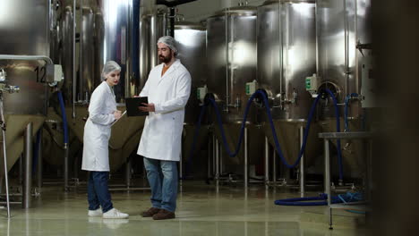 man en vrouw controleren de brouwerij.