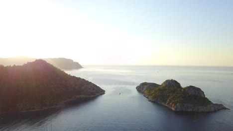 aerial view at the calm bay with yachts on anchor. rising drone shot with sea panorama and sun flare
