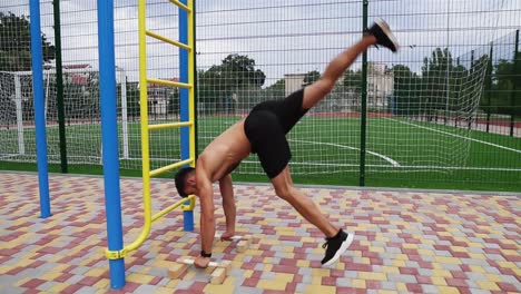 El-Joven-Atleta-Está-Haciendo-Flexiones-Con-Las-Manos-Boca-Abajo-Cerca-De-La-Escalera.-Joven-En-Topless-En-Pantalones-Cortos-Negros