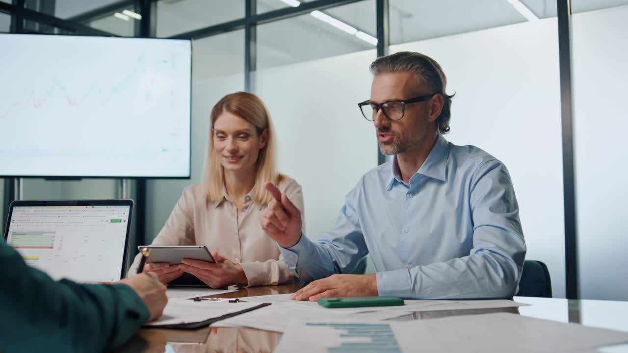 Uomo d'affari emozionato che parla con i partner durante una riunione. Persone che celebrano una partnership.
