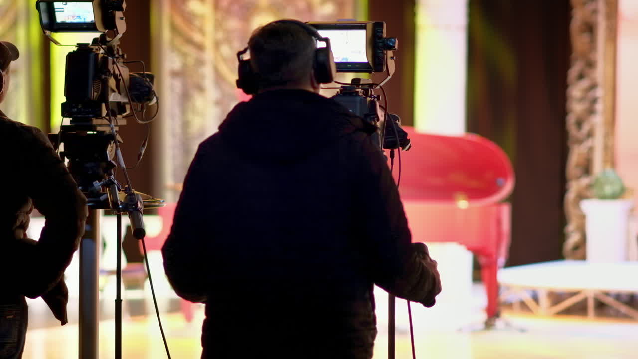 Man filming with professional camera on the backstage of a TV set